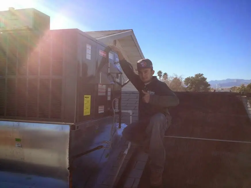 HVAC technician performing AC Tune-Up on a rooftop unit in Ridgefield